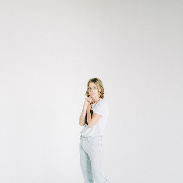 A person stands in a strong and balanced pose against a clean background.