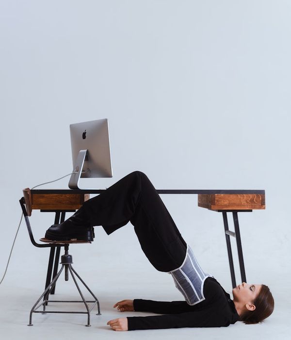 Woman performing a gentle joint mobilization exercise in a modern office.